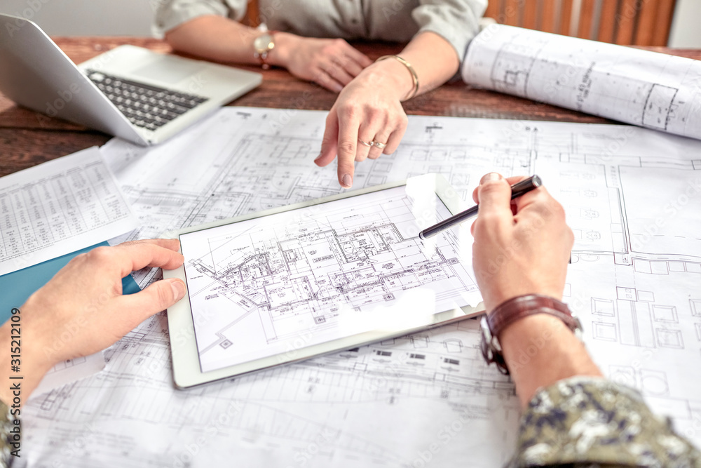 Homeowners and draftsman reviewing ADU plans together at a table